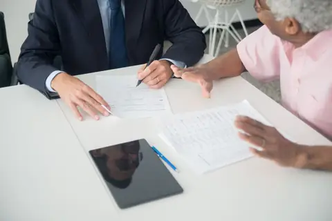 Adviser going through documents with an older client at a table