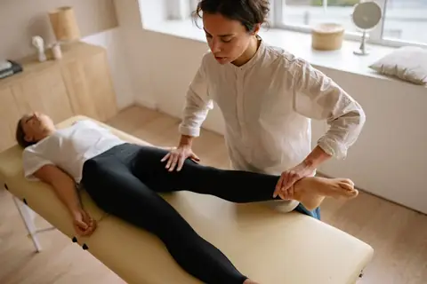 Physiotherapist working through leg rehab with a patient on a treatment table