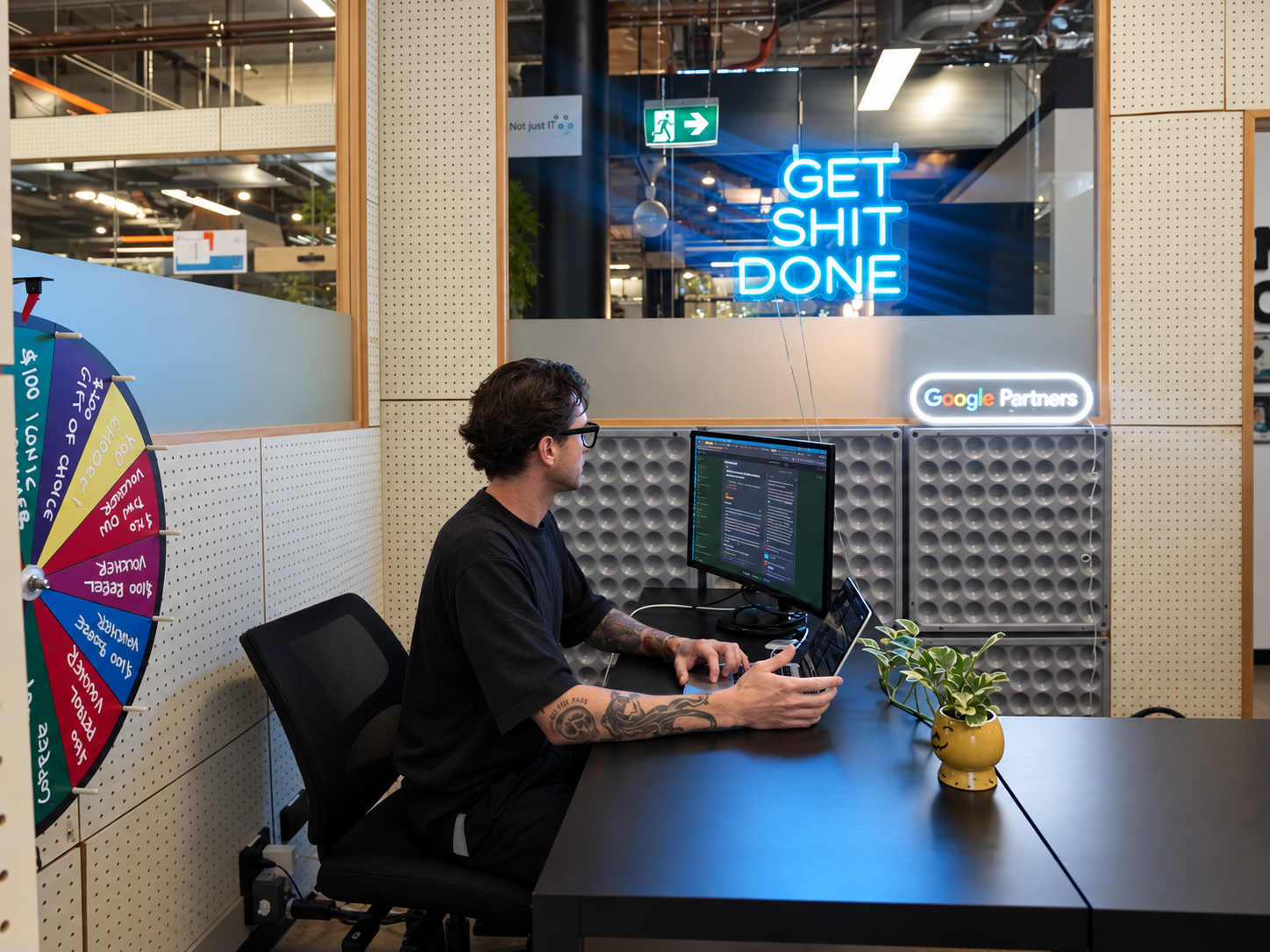Rhys working at a desk with a Google Partner sign behind him