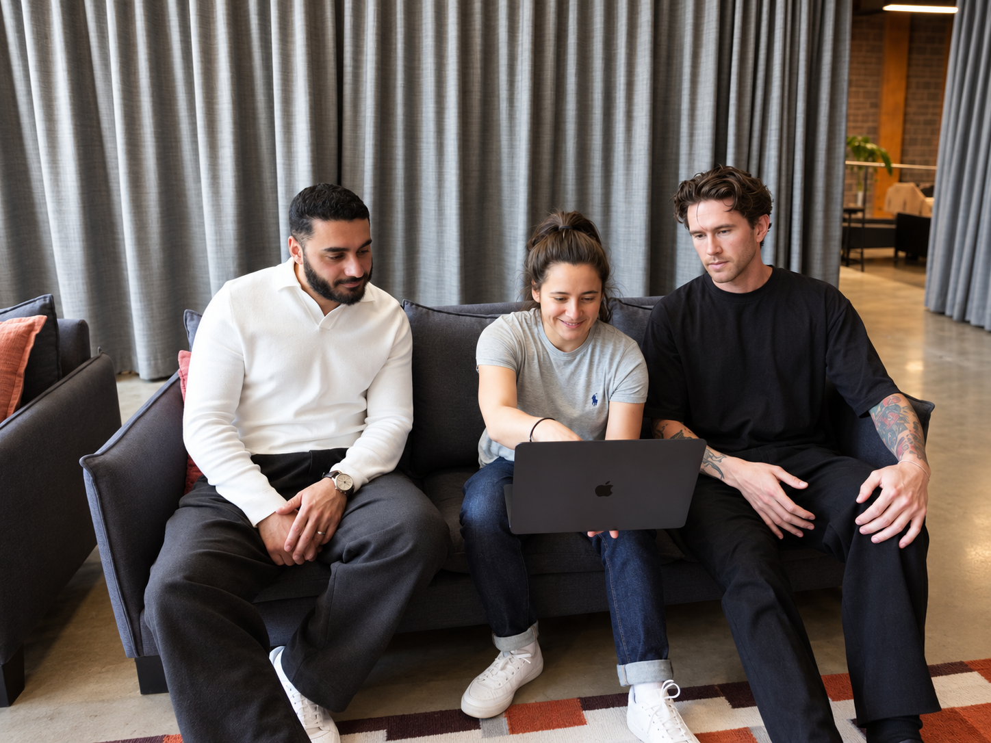Khodar, Sophie and Rhys on a sofa looking at a laptop