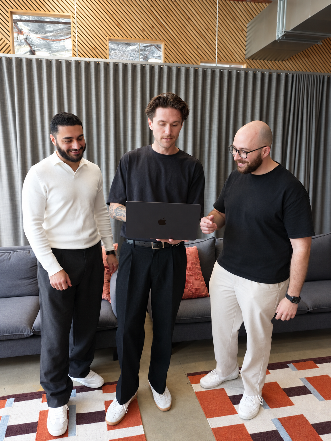 Khodar, Rhys and Lorenzo standing over a laptop